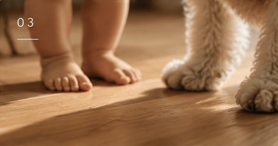 A baby's bare feet and a dog's paws standing on a Bondia floor